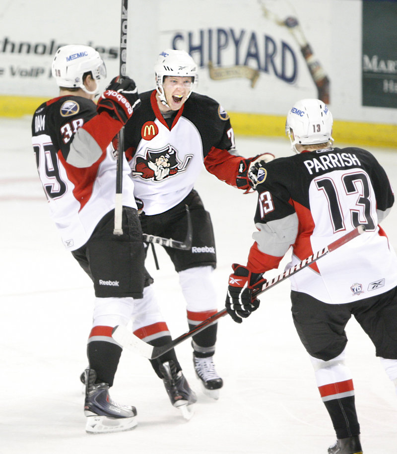 Mark Voakes, center, celebrates his first AHL goal with Portland teammates Luke Adam, left, and Mark Parrish in the first period Sunday afternoon against Springfield. Voakes was called up from the ECHL earlier in the day.