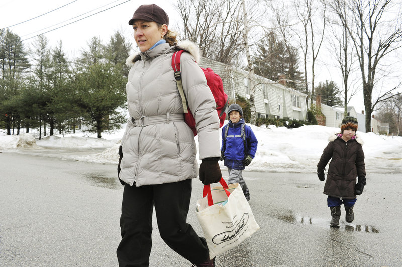 Julie Fitzgerald walks her two children, Louis, 8, and Lia, 5, home from Hall Elementary School each day. She says gaps in the sidewalk system often force them to walk in the street.