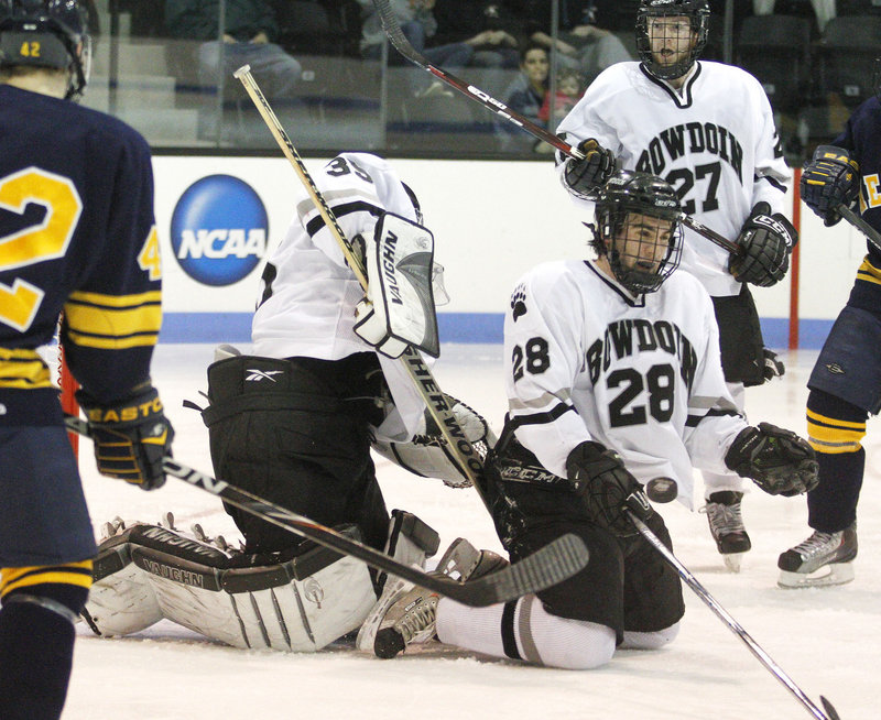 Bowdoin goalie Steve Messina gets help from defenseman Timothy McGarry, who blocks a shot with his body during an NCAA Division III tournament game Wednesday night at Brunswick. Bowdoin advanced by beating Neumann University, 2-1.