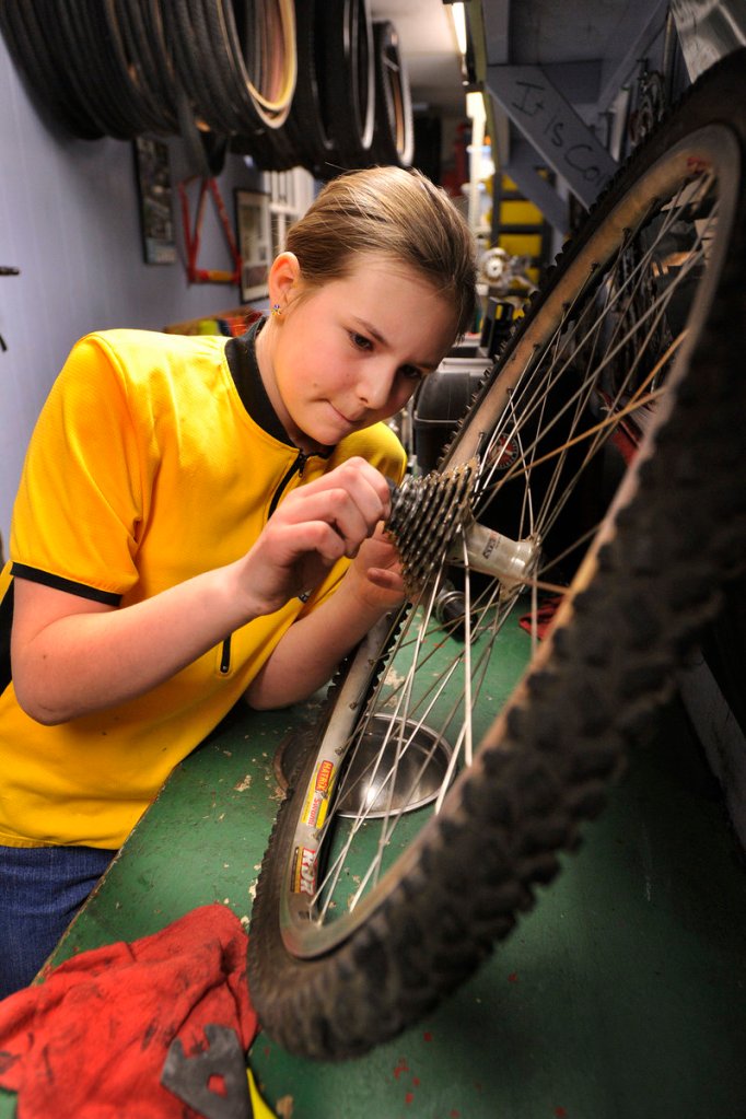 Alexis Gendron, of Biddeford, re-attaches the gear assembly on the rear hub of the bike she's learning to overhaul.