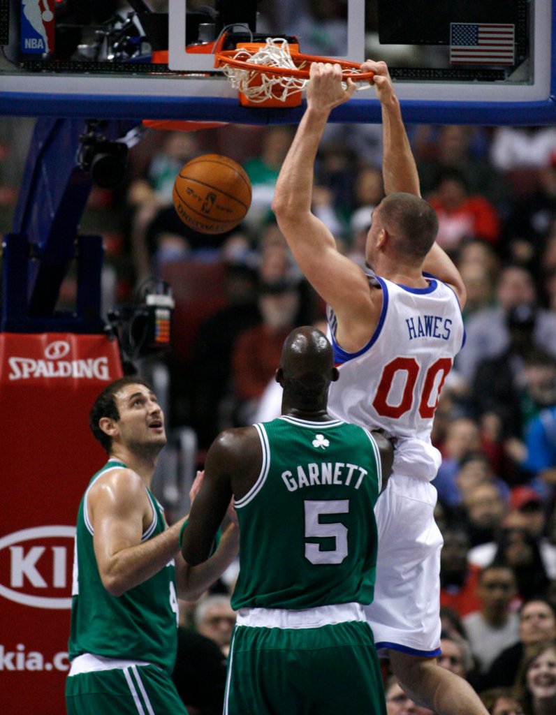 Spencer Hawes of the 76ers dunks between Nenad Krstic, left, and Kevin Garnett of the Celtics on Friday. Hawes had 14 points and 10 rebounds in Philadelphia’s 89-86 victory.