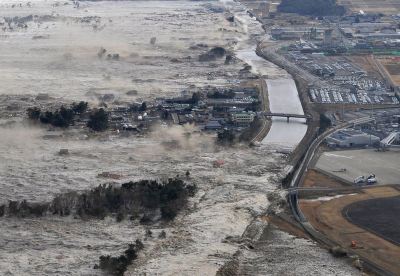 Earthquake-triggered tsunamis sweep the shore along Iwanuma in northern Japan on Friday.
