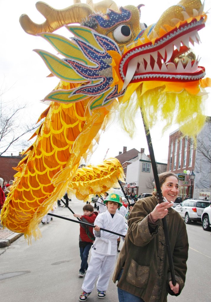 Alysha Carabetta of West Bath carries a colorful dragon down Front Street with members of Five Elements Mountain School of Martial Arts during the Bath Blarney Days parade.