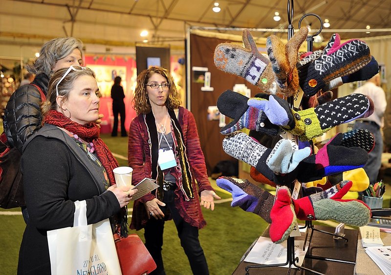 Marilyn Robertson of York Harbor-based Jack and Mary Handbags, right, talks to Julia Dickenson, front, of Norwich, Vt., and Ingrid Ellison of Camden at the New England Products Trade Show on Saturday.