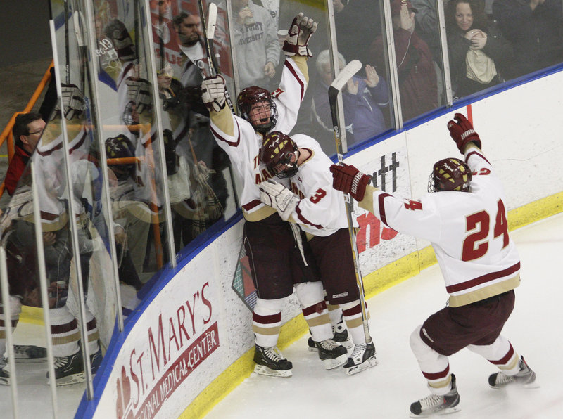 Sam Canales of Thornton Academy celebrates with C.J. Maksut, 3, and Tyler Danley, 24, after scoring Saturday night in the second period of the Class A final against Lewiston.