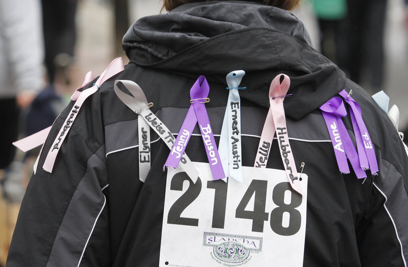 Sue Burgess of Saco wears ribbons on her jacket during Mary’s Walk to recognize more than 40 relatives and friends who have been afflicted with cancer. The different colors symbolize different types of the disease.
