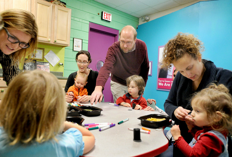 Reporter Ray Routhier works with 2-year-old Elias Botefield and other children creating noisemakers at the Children's Museum & Theatre of Maine in Portland.