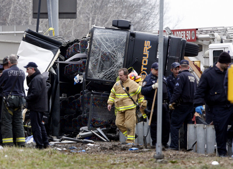 Rescue workers investigate a bus crash in the Bronx on Saturday. Fourteen people died in the accident.