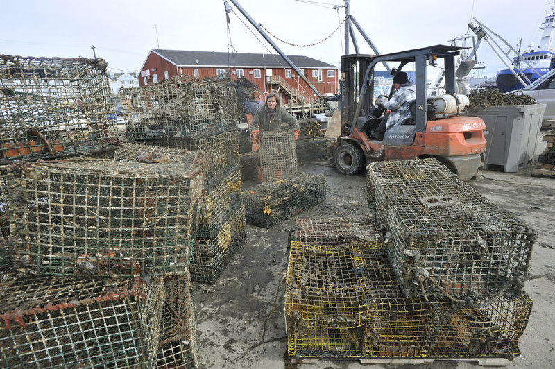 Retrieved lobster traps are unloaded onto the Portland Fish Pier. One boat recovered 60 traps Monday, and the boats will be going out again today.