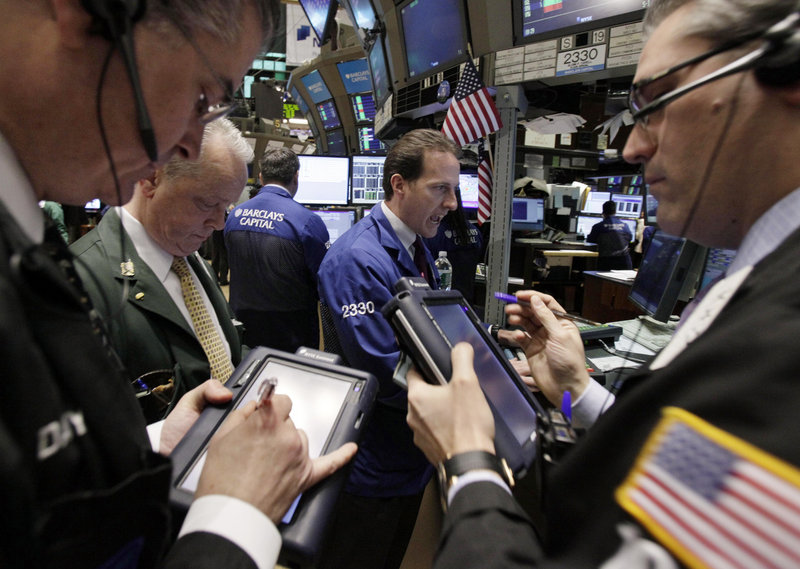 Specialist Glenn Carell, background center, works at his post on the floor of the New York Stock Exchange on Monday, when there was a broad sell-off.