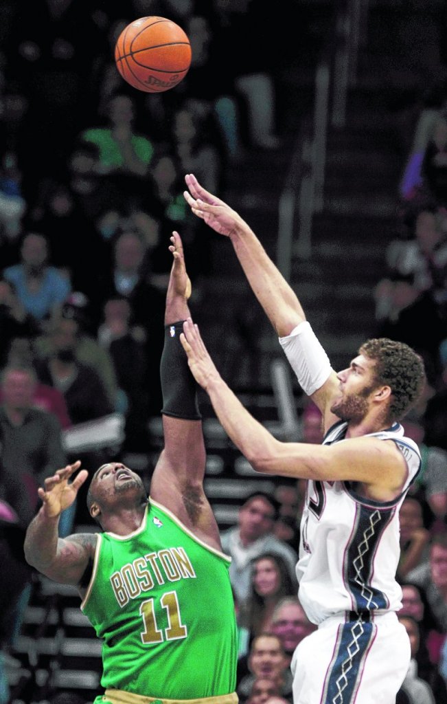 Brook Lopez, who scored 20 points Monday night for the New Jersey Nets, takes a shot over Glen Davis of the Boston Celtics in the first quarter of the Nets’ 88-79 victory.