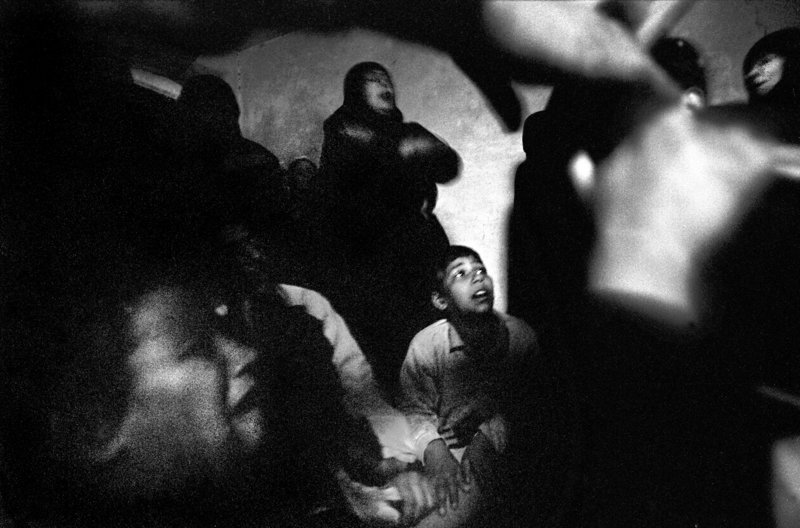 Sadr City Shiites pray and wail in the darkness amid bombing and heavy fighting in the Baghdad slum in April 2004. They had gathered in a home for the funeral of a young man killed earlier that day by U.S. soldiers. The April uprising, in which Shiites took up arms against the occupation en masse for the first time, was one of the bloodiest months since the war in Iraq began in 2003.