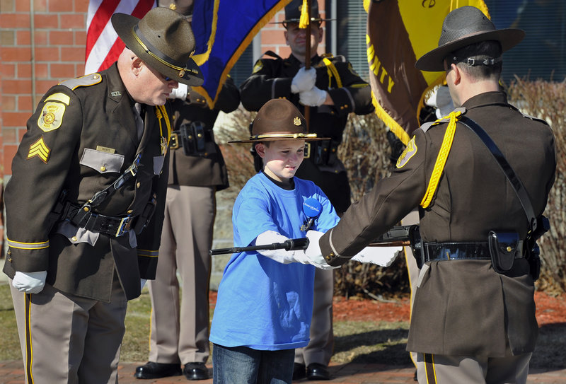 Guided by Sgt. Paul Thorpe, left, Cameron Tufts, 9, of New Gloucester takes part in a “white glove military inspection” as he gets to be “Deputy Sheriff for a Day” on Thursday in Portland.