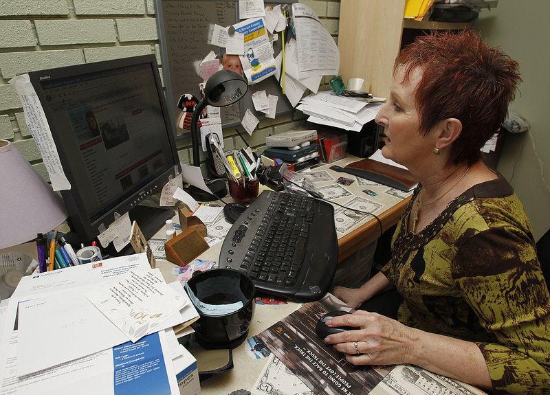 The Associated Press Judy Bates searches on her computer looking for good deals at her home, in Dora, Ala. Many people are being affected by the squeeze of higher prices for food, gas, utilities, insurance and health care.