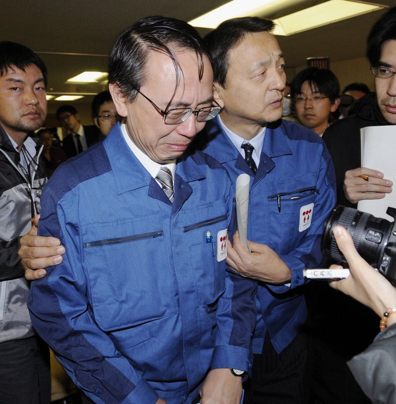 Tokyo Electric Power Co. Managing Director Akio Komori, center, sheds tears as he leaves a news conference in Fukushima on Friday, a week after an earthquake and resulting tsunami triggered a historic nuclear crisis in Japan.