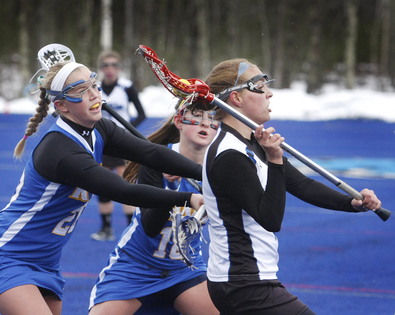 Sadie MacLean of UNE looks to pass as she’s chased by Jen Perry, left, and Tina Carpenter of Roger Williams in a women’s lacrosse game at Biddeford. Roger Williams took control with a 12-3 run late in the first half for a 21-12 win.