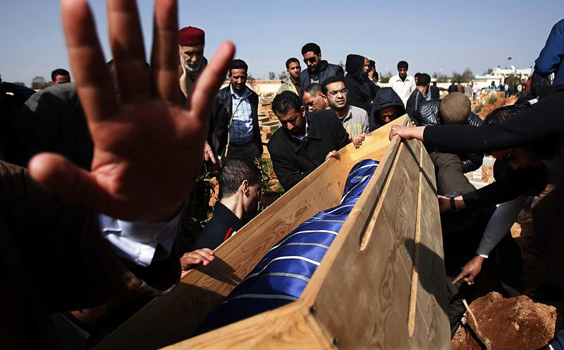 Mourners lower the body of a man into a grave in Benghazi, Libya, earlier this month. The man succumbed to wounds suffered Feb. 17, at the start of an uprising against Libyan dictator Moammar Gadhafi. Many believe the courage to rebel came from the daring shown in early protests of the 1996 killings of inmates in a Tripoli prison.