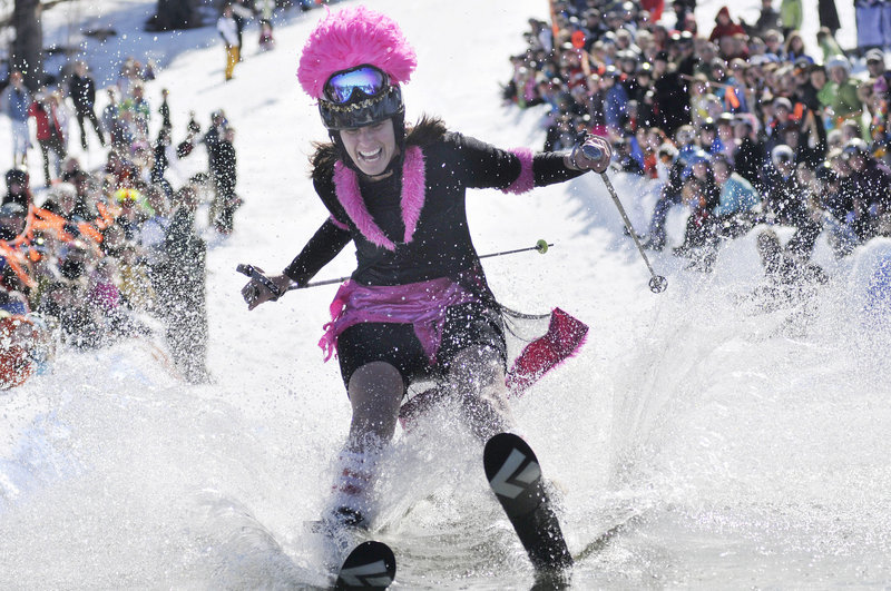 Janice Perrin gives it her all as she tries to cross 100 feet of water on skis during the Slush Cup contest at Shawnee Peak in Bridgton on Saturday.
