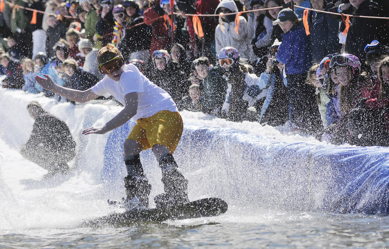 Chris Anderson of Massachusetts rides a snowboard across the man-made pond.