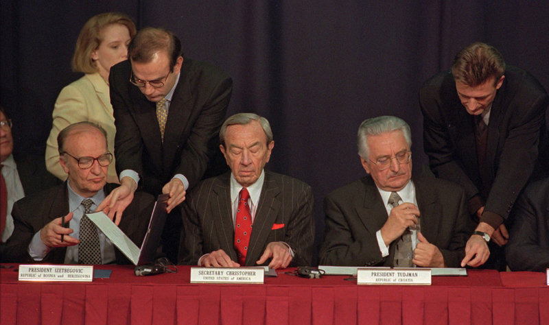 Then-Secretary of State Warren Christopher, center, is flanked by Bosnian President Alija Izetbegovic, left, and Croatian President Franjo Tudjman as they sign the Dayton peace accord on Nov. 10, 1995. Christopher died Friday at age 85.