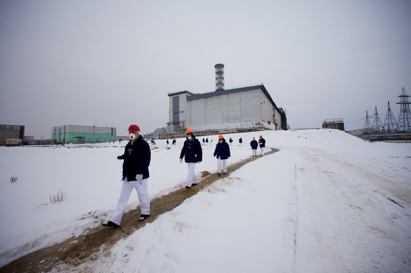 Workers and visitors wearing protective clothing walk on the grounds of the Chernobyl nuclear power plant in Ukraine in this Feb. 24 photo. They are working on a shelter to cover the building where a reactor exploded on April 26, 1986, spewing radioactive fallout over much of the Northern Hemisphere.