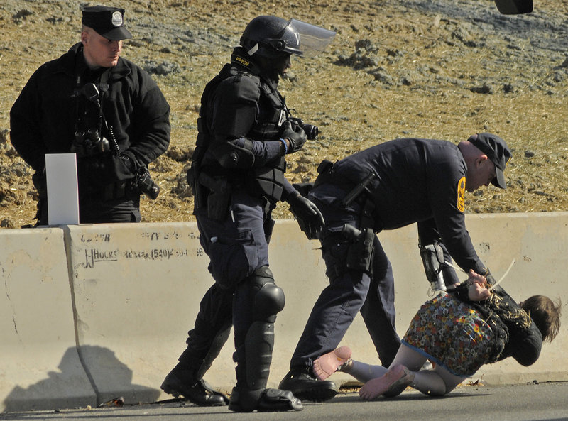 Members of the Virginia State Police handcuff a protester Sunday afternoon in Quantico, Va.