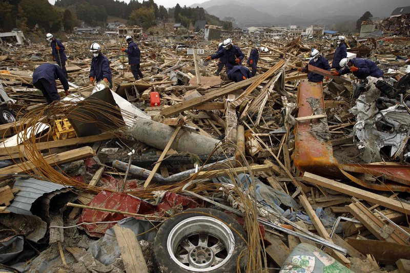 Police officers search through debris in a residential area destroyed by the March 11 earthquake and tsunami in Rikuzentakata, Iwate Prefecture, Japan, on Sunday. The safety of food and water is a growing concern in Japan.