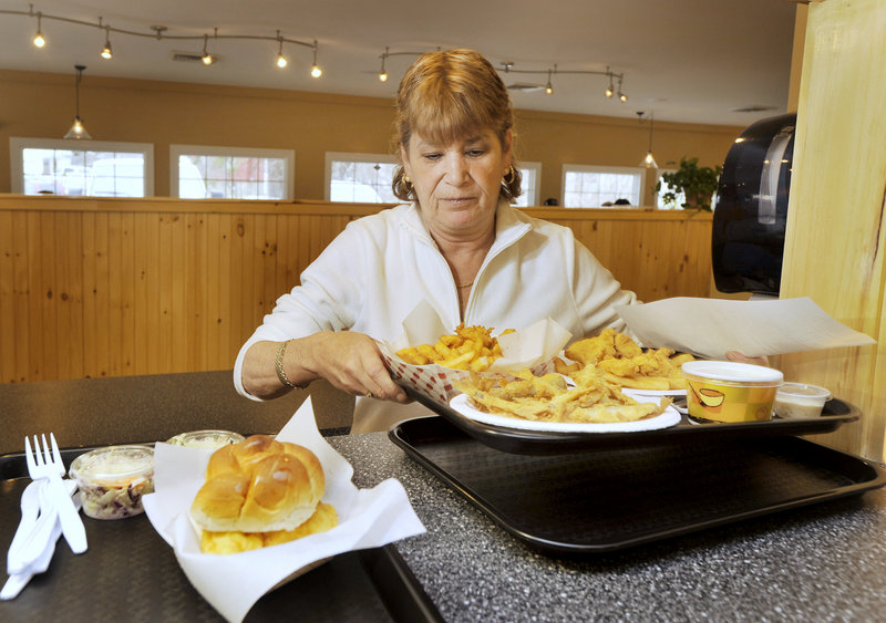 Brenda Mershimer prepares to serve several lunch orders fresh from Docks’ kitchen. Besides seafood, Docks serves burgers, chicken, kids’ meals and more.