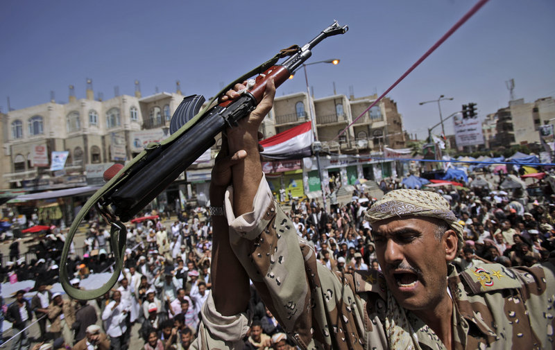 A Yemeni army officer holds up his AK-47 as officers joined protesters demanding the resignation of Yemeni President Ali Abdullah Saleh in Sanaa, Yemen, on Monday.