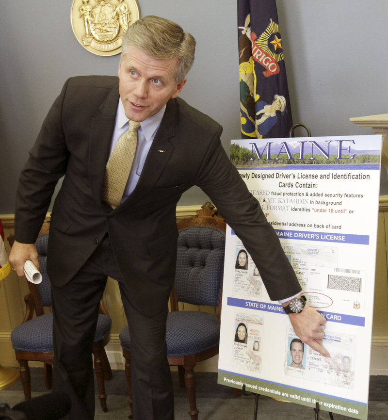 Secretary of State Charlie Summers points to a poster of the new Maine driver’s license design, featuring updated security enhancements, at a news conference Tuesday. There also are vertical formats for cardholders below the age of 21.