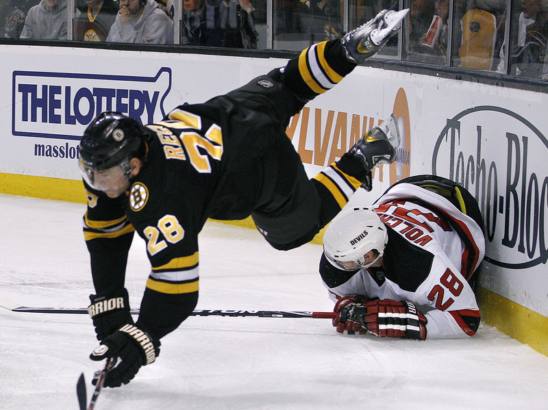 Bruins left wing Mark Recchi goes flying over New Jersey defenseman Anton Volchenkov during division-leading Boston’s 4-1 win at home on Tuesday.