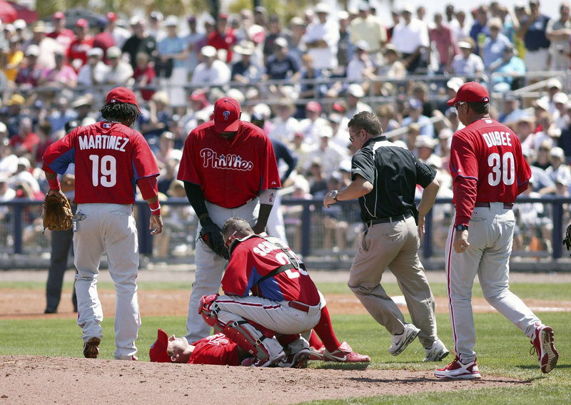 Teammates and trainers rush to pitcher Roy Oswalt after he was struck on the neck by a line drive by Tampa Bay's Manny Ramirez in an exhibition game Wednesday in Port Charlotte, Fla. An MRI showed Oswalt only suffered a bruise.