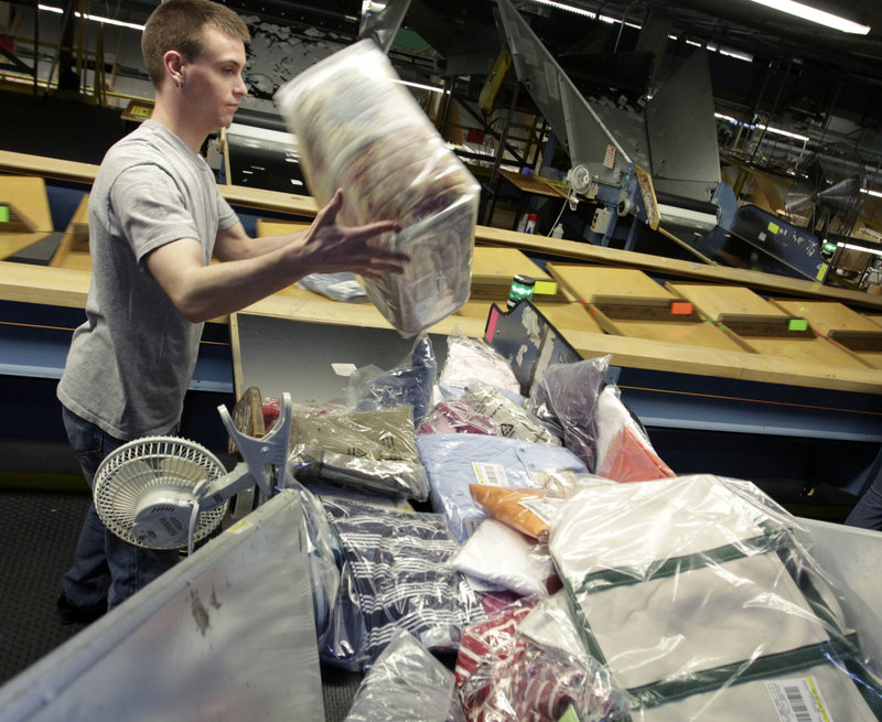 Justin Reil of Brunswick handles merchandise for shipping at an L.L. Bean facility in Freeport on Thursday. A spokesman says the company’s free shipping offer comes with no strings attached.