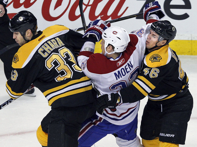 Boston teammates Zdeno Chara, left, and David Krejci sandwich Montreal’s Travis Moen at the TD Garden on Tuesday night. The win gives Boston a five-point lead on Montreal in the Northeast Division.