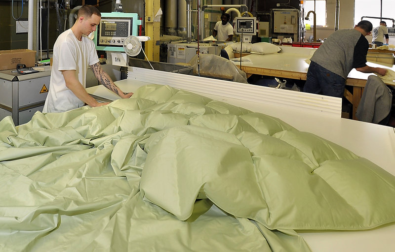 Bobby Hipsher fills a colored baffled comforter with down at the Cuddledown factory in Portland.