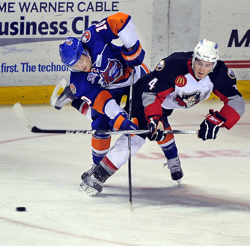Corey Tropp, right, of the Pirates and Bridgeport’s Rhett Rakhshani collide and the puck slides away during their game Friday night at the Civic Center. The Sound Tigers won on the road for just the seventh time this season.