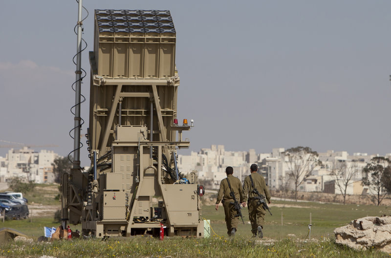 Israeli soldiers walk next to the Iron Dome, a new anti-rocket system, near the Israeli city of Beersheba on Sunday. Weeks of stepped-up rocket and mortar attacks have drawn fears of renewed war and led to new calls in Israel for the military to deploy the $200 million anti-rocket system.