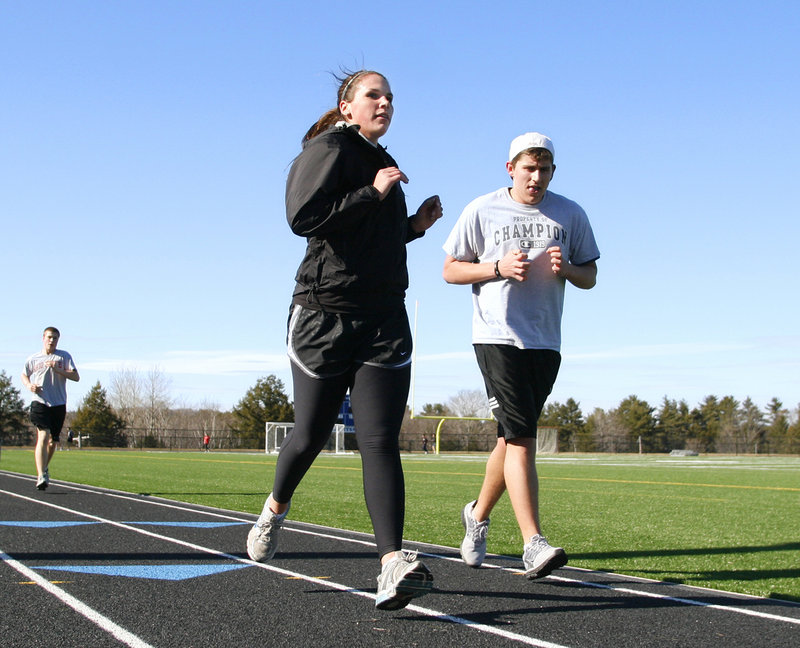 Jenna Serunian and Andrew Kowalsky take a few laps at the track at Falmouth High School as part of the outdoor track team's opening-day practice.