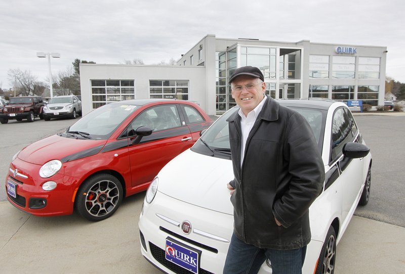 Jack Quirk shows off two new Fiat 500 cars at his dealership in Portland. In the background is the building being renovated to be the new Fiat studio.