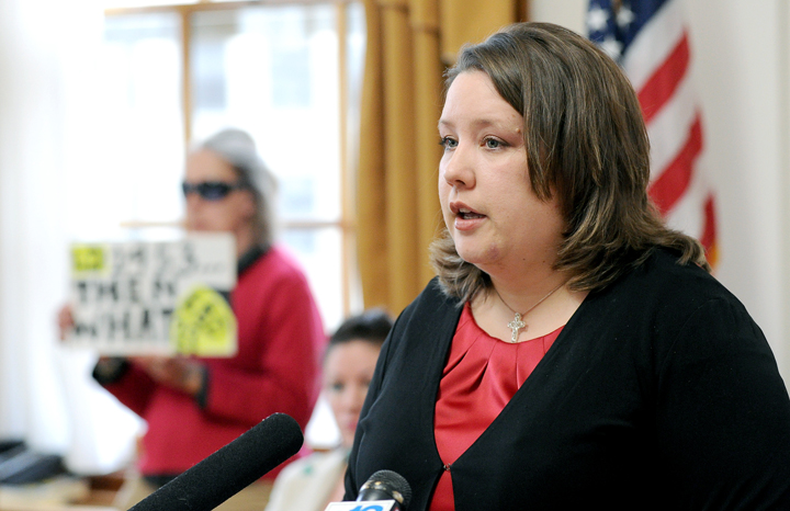 With a lone protester in background, Rep. Diane Russell holds a press conference at Portland City Hall today to introduce the bill she has sponsored to legalize and tax marijuana in Maine.