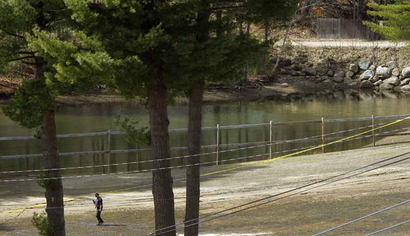 A man with a camera walks past the retention pond at Mount Cranmore today.