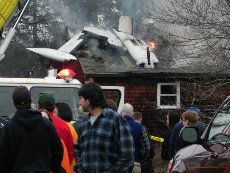 A crowd gathers at the Biddeford home where an airplane crashed about 6 p.m. today.