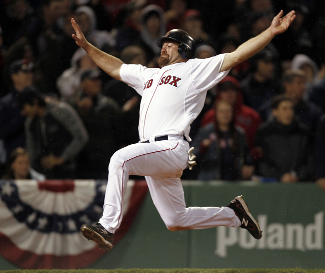 Boston Red Sox's Kevin Youkilis goes flying into home to score on a double by David Ortiz during the eighth inning of Boston's 4-0 win over the New York Yankees Sunday at Fenway.