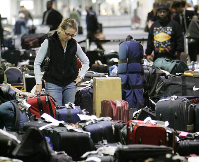 An airline passenger searches through luggage at Philadelphia International Airport.