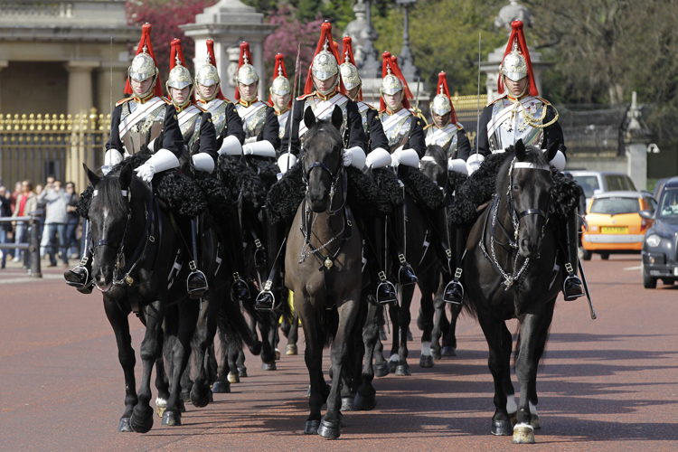 The Blues & Royals of the Household Cavalry Mounted Regiment ride pass Buckingham Palace in London on their way to the Horse Guards Parade, Wednesday, April 6, 2011. The Blues & Royals together with the Life Guards will form a Sovereign's Escort for Queen Elizabeth II and a Captain's Escort for the bride and groom from Westminster Abbey to Buckingham Palace during the royal wedding of Prince William and Kate Middleton on April 29, 2011. (AP Photo/Sang Tan)
