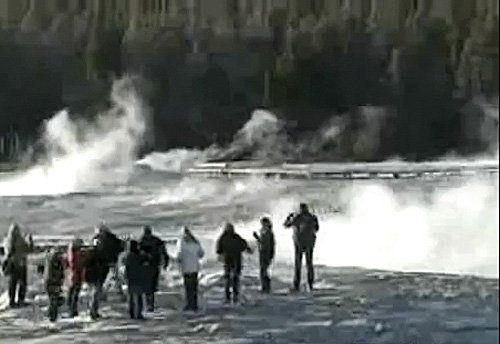 A group of tourists stand dangerously close to the iconic Old Faithful geyser in Yellowstone National Park in Wyoming on Wednesday, April 27, 2011, in this still made from National Park Service video.