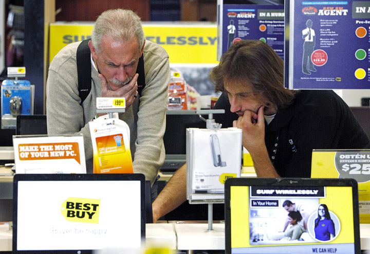 A customer shopping for a laptop computer is assisted by a Best Buy sales associate in Glendale, Calif., Wednesday.