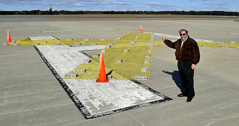 Steve Levesque explains last Wednesday how these large yellow X’s, required by the Federal Aviation Administration on a closed airport runway, were being removed in preparation for the opening of the old Brunswick Naval Air Station’s runway for use by general aviation. The Brunswick Executive Airport opened on schedule Saturday at the BNAS site.
