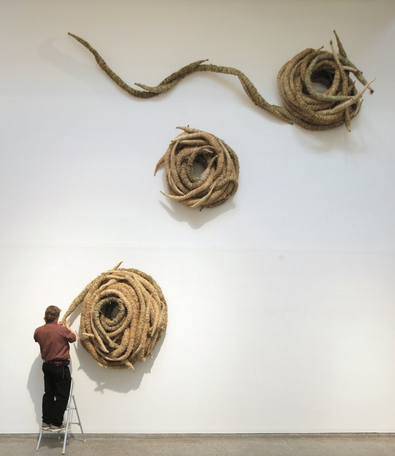 Michael Shaughnessy is shown early in the installation of his hay-and-twine piece called “Cascade, Current and Pool” for the 2011 Biennial in the Portland Museum of Art’s Great Hall.