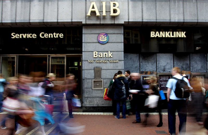 People wait to use the cash machine Thursday at an Allied Irish Bank in Dublin. The government intends to create “two pillar banks” for the financial system, Allied Irish and the Bank of Ireland. The other Irish-owned banks would be dismantled.